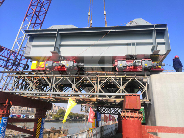 Steel box beams are placed on top of 4 three-dimensional adjustment hydraulic trolleys