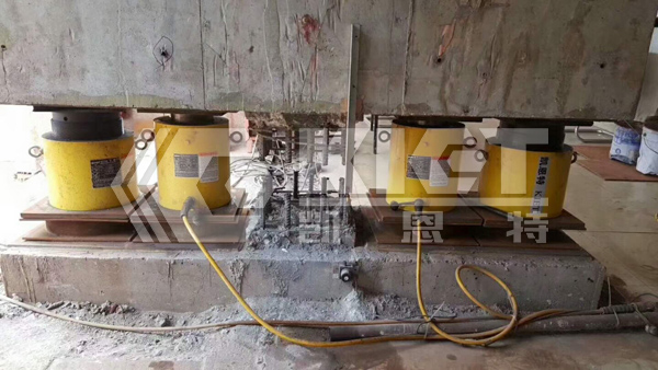 Synchronized Lifting of Buildings with Single-Acting High-Tonnage Cylinders